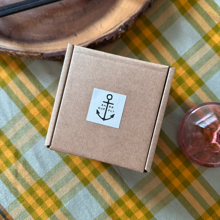 Brown cardboard box with a logo on a checkered tablecloth